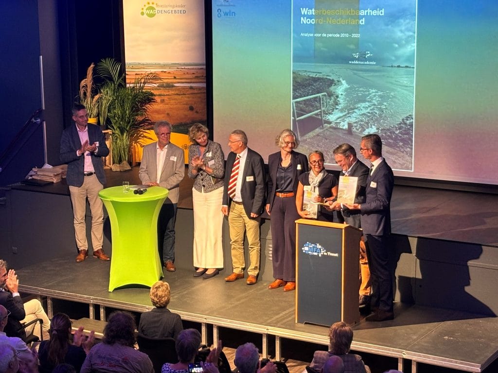 Groepsfoto van de in ontvangstneming van het Waddenacademie rapport over zoetwaterbeschikbaarheid in de Waddenkust tijdens het symposium Van Dijkversterking naar Klimaatadaptieve Waddenkust